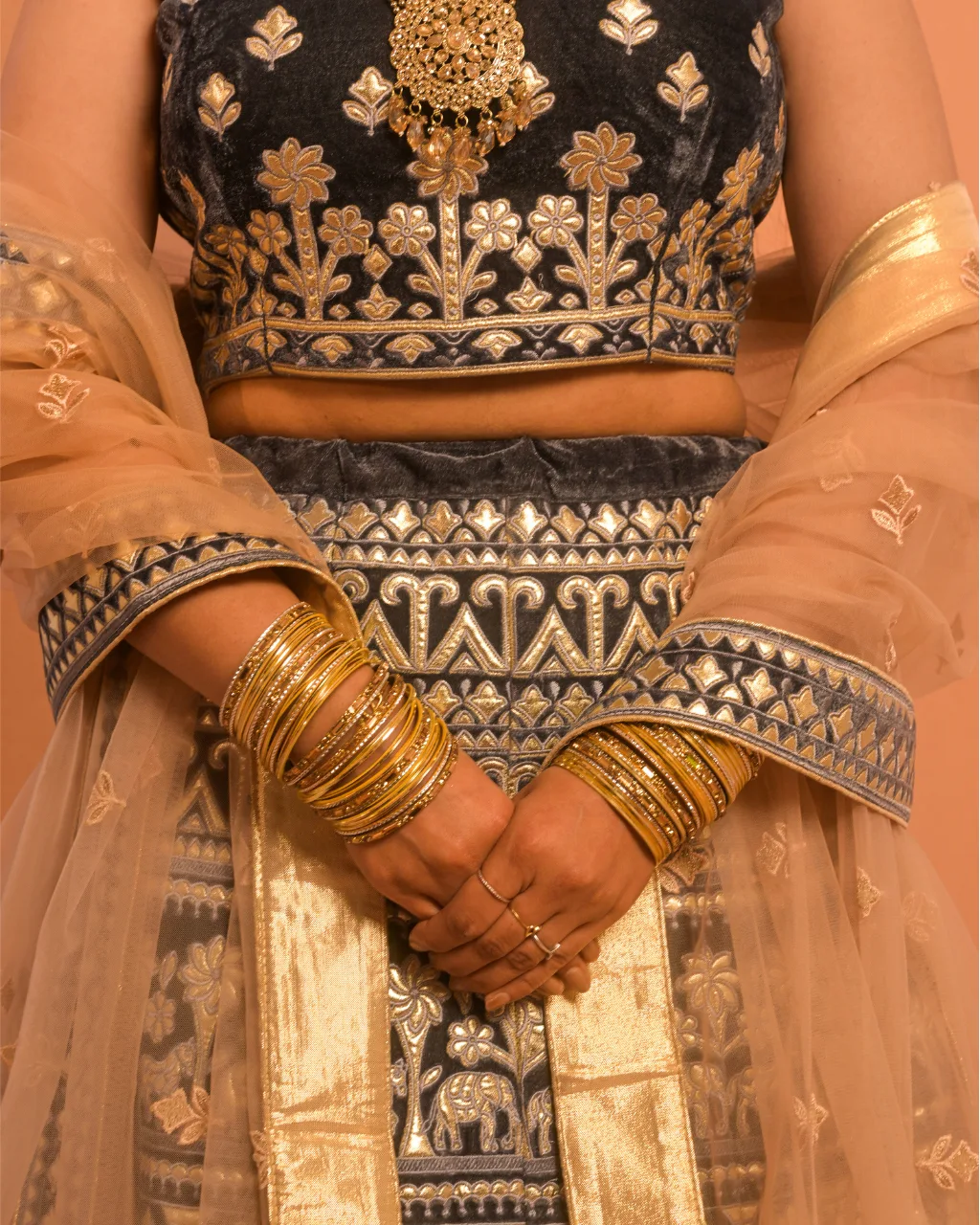 close up of embroidered bridal lehenga choli with detailed handwork and jewelry